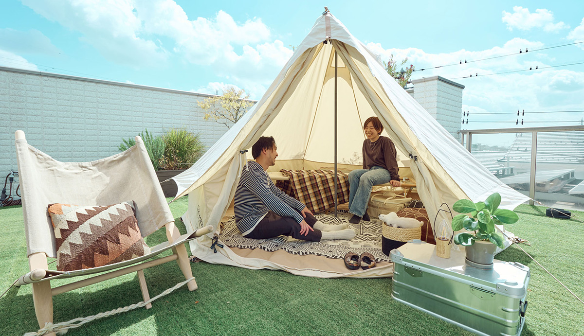 ヘーベルハウス駒沢第三展示場の屋上に設営したデンマーク発祥のブランドnordisk(ノルディスク)の看板製品ワンポール式テント「アスガルド」で夫婦が楽しむ様子