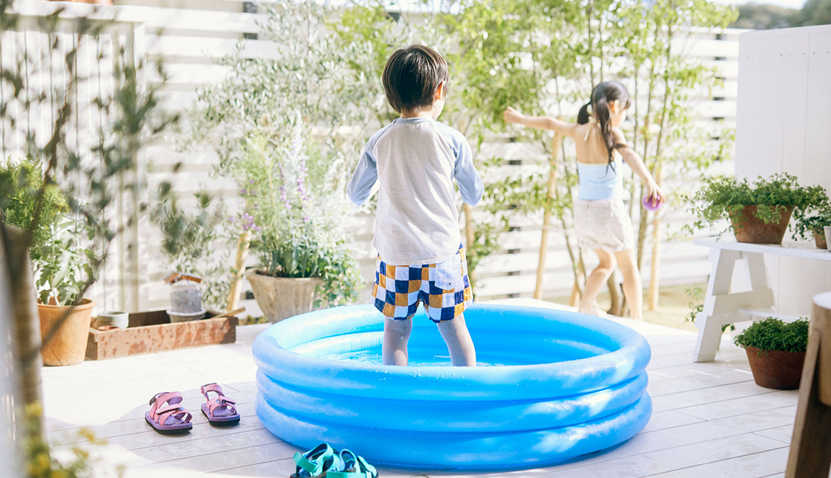 ヘーベルハウスLONGLIFE IS BEAUTIFUL のきのまでプールを広げて楽しむ子どもたち