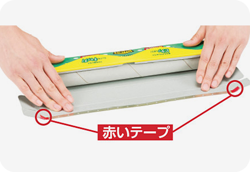 フタ全体を平らに広げて手で押さえます。（刃をはがしやすい赤いテープが刃の端についています。）