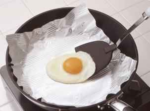 画像：クックパーフライパン用ホイルを、フライパンに敷いて目玉焼きを作っている