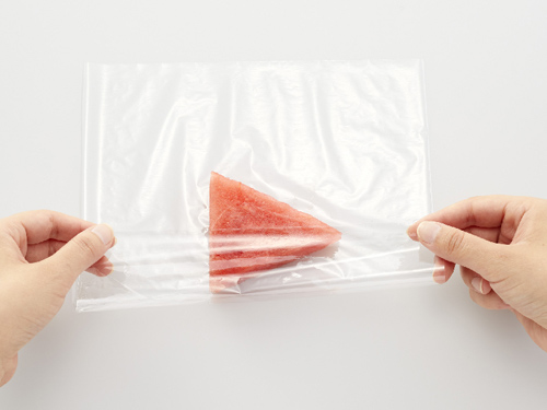 画像；スイカをサランラップで包んでいる